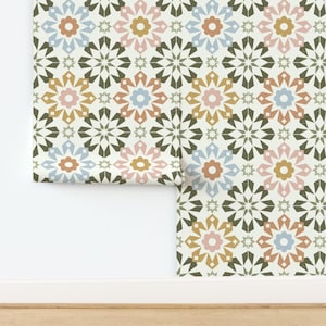May include: A repeating pattern wallpaper with a white background and a geometric design featuring multi-colored flowers with a starburst pattern. The colors are pink, blue, yellow, and green.