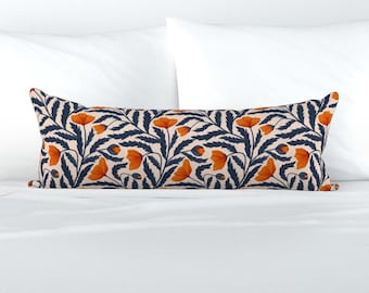 Può includere: Un lungo cuscino lombare rettangolare caratterizzato da un motivo botanico ripetuto di fiori di papavero arancione brillante e fogliame blu navy scuro su uno sfondo color crema chiaro. Il disegno copre l'intera superficie anteriore.
