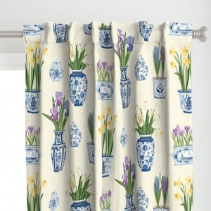 May include: A white curtain with a repeating pattern of blue and white porcelain vases filled with yellow daffodils, purple irises, and blue hyacinths.