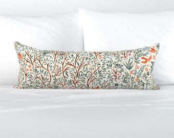 May include: A long rectangular pillow with a white background and a repeating pattern of green branches, orange birds, and pink flowers.