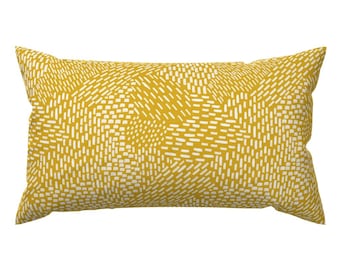 Puede incluir: Una almohada amarilla con un patrón geométrico blanco.