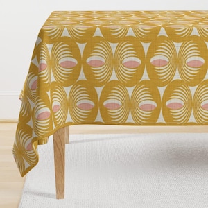 Puede incluir: Un mantel amarillo con un patrón repetido de círculos rosas y blancos. El mantel está hecho de una tela similar al lino.