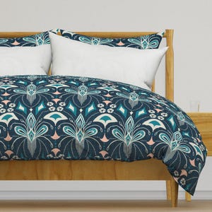 May include: A teal and pink patterned duvet cover with a geometric design. The duvet cover is on a wooden bed frame.