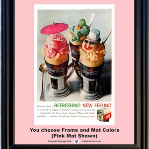 May include: Framed vintage Coca-Cola advert showing ice cream floats. The image displays three floats with decorative toppings in Coca-Cola glasses. The frame is black, and the mat is pink. Text includes "Refreshing New Feeling" and "You choose Frame and Mat Colors".