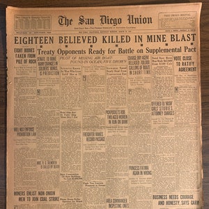 May include: A vintage newspaper, "The San Diego Union," with headlines about a mine blast, a missing air boat, and prohibition. The paper is aged with visible creases and wear, showcasing its historical context.