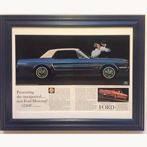 May include: A framed vintage advertisement for a Ford Mustang featuring a blue hardtop model with a white roof, a couple, and text including 'Presenting the unexpected... new Ford Mustang!' and '$2368'. A smaller red convertible is also shown.