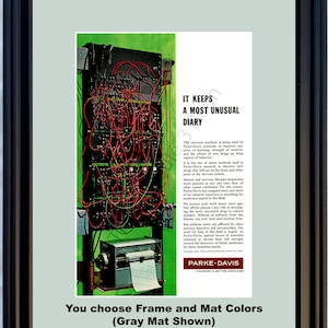 Może przedstawiać: Oprawiona, zabytkowa reklama z czarną ramą i szarą matą. Reklama przedstawia skomplikowaną maszynę z czerwonymi przewodami na zielonym tle. Tekst zawiera "IT KEEPS A MOST UNUSUAL DIARY" i "PARKE-DAVIS".