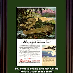 Peut inclure: Publicité vintage encadrée pour le Studebaker Weasel, un véhicule militaire, dans un paysage de jungle. L'annonce comprend du texte et une petite image d'un avion. Le cadre est marron foncé et le passe-partout est vert forêt.