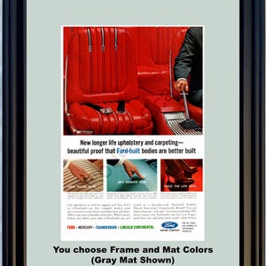 May include: Framed vintage advertisement showcasing a red car interior with text. The ad promotes Ford's upholstery and carpeting, with material close-ups. The frame is black, and the mat is grey.