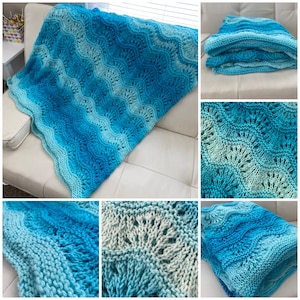 May include: A crocheted blanket in shades of blue and green with a wave pattern. The blanket is folded and displayed on a white couch.