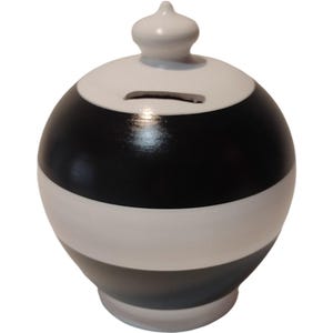 May include: A ceramic piggy bank with a round shape, painted with horizontal bands of black, white, and gray. The top features a slot for inserting coins and a small, white, decorative knob. The bank has a glossy finish.