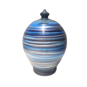 Pode incluir: Um cofrinho de cerâmica listrado azul e branco com uma tampa preta.