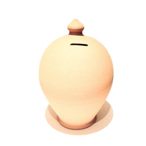May include: A light beige ceramic piggy bank with a rounded body and a small, decorative top. The bank has a coin slot on the top and sits on a circular base. The overall shape is reminiscent of a vase.