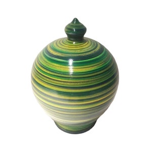 May include: Green and yellow striped ceramic money box with a rounded shape and a pointed lid.