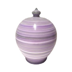 May include: A purple and white striped ceramic piggy bank with a rounded shape and a small lid.