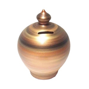 以下が含まれることがあります： 茶色、金色、銅色の渦巻き模様が施された陶器製の貯金箱。貯金箱の上部にはコインを入れるための小さな穴があります。