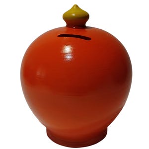 Könnte beinhalten: Ein runder, orangefarbener Sparschwein mit gelbem Deckel. Die Bank hat einen Schlitz zum Einwerfen von Münzen und besteht aus einem glatten, glänzenden Material. Ein klassisches Design zum Sparen von Geld.