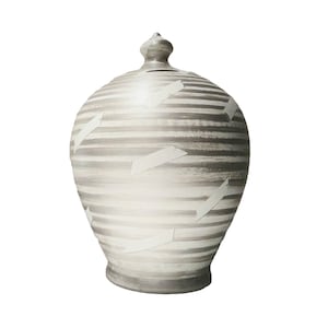 May include: A white ceramic piggy bank with a striped pattern and white accents. The piggy bank has a round body and a small opening on the top.