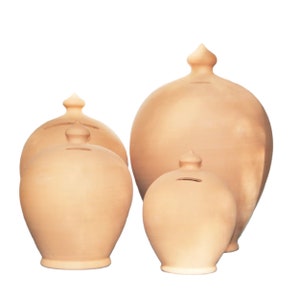 Peut inclure: Quatre tirelires en terre cuite de tailles différentes, toutes de forme arrondie et avec une petite ouverture sur le dessus. La plus grande tirelire est à l'arrière, et la plus petite est à l'avant.