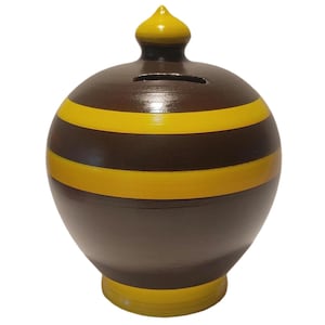 Peut inclure: Une tirelire sphérique présentant une couleur de base marron foncé avec deux bandes horizontales jaunes entourant la section centrale. Le sommet possède un couvercle pointu jaune et une fente, tandis que la base est un socle circulaire jaune.