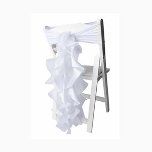 May include: White chair sash with a ruffled fabric tail. The sash is tied around the back of a white folding chair.