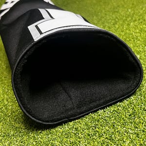 Peut inclure: Une housse de club de golf noire avec un motif graphique blanc sur l'ext&eacute;rieur et une doublure en polaire noire douce &agrave; l'int&eacute;rieur. La surface ext&eacute;rieure pr&eacute;sente des lettres blanches partielles et des formes g&eacute;om&eacute;triques.