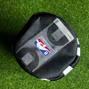 Peut inclure: Un maillot de sport noir dot&eacute; d'un &eacute;cusson rectangulaire gris avec le logo NBA Authentics, un graphique de terrain de basket et l'&eacute;tiquette de taille 2XL. Le v&ecirc;tement est fabriqu&eacute; dans un tissu en maille textur&eacute; et respirant avec des coutures visibles.