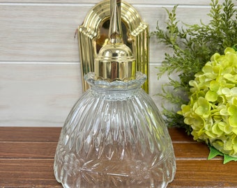 Aplique de pared estilo Hollywood de latón vintage con pantalla de cristal festoneada.