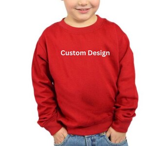 Puede incluir: Una sudadera roja de manga larga con el texto "Custom Design" impreso en la parte delantera.