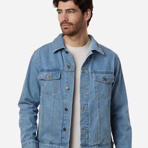 May include: Light blue denim jacket with two chest pockets and button closures. The jacket has a classic collar and long sleeves. The jacket is a light wash denim and has a casual style.