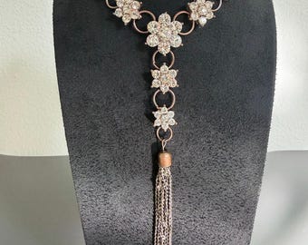 Collar vintage con colgante en forma de Y, borla y diseño floral escalonado con pedrería.