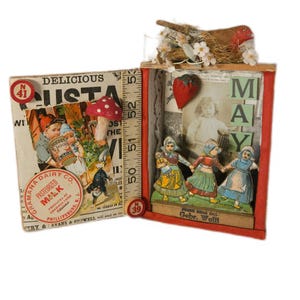 May include: A mixed media art piece featuring a diorama with a vintage aesthetic. It includes a miniature scene with paper dolls, a strawberry, and the word "MAY". The left side has a vintage milk ad and a mushroom.