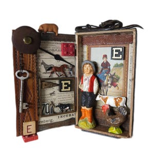 May include: A handcrafted, open-faced box with a clock, key, and miniature farm animals. The box features a clock face, a pig figurine, and a small figure of a farmer. The box also includes a picture of a woman riding a donkey.