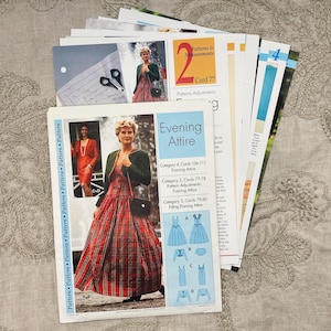 May include: A collection of sewing pattern instruction cards featuring Evening Attire. The top card displays a person wearing a red plaid dress with a dark green bolero jacket, alongside technical sketches labeled A, B, C, and D for garment construction.