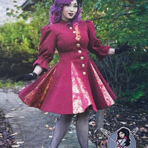 May include: A deep red knee-length dress with three-quarter length sleeves, a high neckline, and a row of gold-toned buttons down the front. The skirt features contrasting gold and red floral patterned panels, paired with black fishnet stockings.
