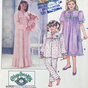 May include: A sewing pattern envelope featuring illustrations of three nightgowns and pajamas. One is a long pink floral nightgown, one is a white pajama set with small hearts, and one is a purple nightgown. Includes Cabbage Patch Kids logo.