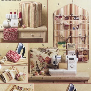 Puede incluir: Una colección de suministros de costura y manualidades, que incluye una máquina de coser, una plancha, alfileteros y una bolsa de almacenamiento a rayas. La imagen también presenta una funda de máquina de coser con estampado floral y un organizador de pared.