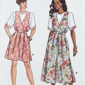 May include: A sewing pattern illustration featuring two variations of a short-sleeved jumpsuit worn over a white t-shirt. Version A is a coral jumpsuit with a white spiral pattern. Version B is a sage green jumpsuit with a red floral print.