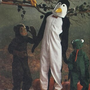 May include: Three children's costumes: a monkey, a penguin, and a frog. The penguin costume is white with black wings and a headpiece. The monkey costume is brown, and the frog costume is green. All three costumes are full-body suits.