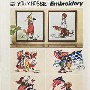 May include: A Holly Hobbie embroidery pattern sheet featuring multiple illustrations of children in various activities, including holding American flags, playing drums, and riding bicycles. The text reads ONE SIZE HOLLY HOBBIE Embroidery.