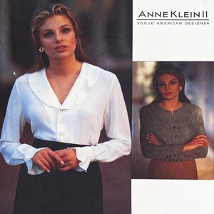 May include: A sewing pattern envelope for Anne Klein II Vogue American Designer featuring two blouse styles. Style A is a white long-sleeve button-down blouse with a ruffled collar and cuffs. Style B is a grey textured long-sleeve blouse with a round neckline.