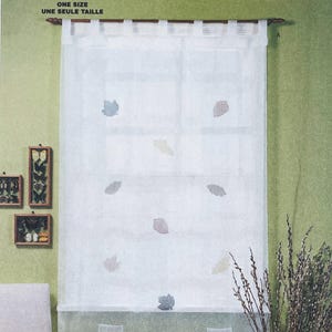 May include: White sheer curtain with leaf accents, hanging from a wooden rod. The curtain has a light, airy appearance and is decorated with various colored leaf shapes. The text "ONE SIZE UNE SEULE TAILLE" is at the top.