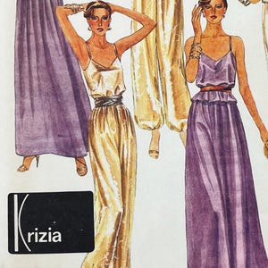 May include: A vintage sewing pattern illustration featuring three outfits: a long purple skirt, a gold jumpsuit with a dark waistband, and a purple dress with a peplum waist and thin straps. The Krizia logo is printed in white on a black rectangle.