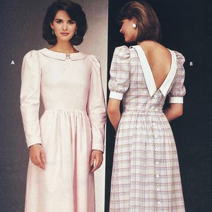 May include: Two dresses are shown. One is a light pink, long-sleeved dress with a Peter Pan collar and a gathered waist. The other is a plaid dress with short, puffed sleeves, a white collar, and a low back with buttons.