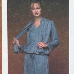 Può includere: Completo blu chiaro a due pezzi. La parte superiore presenta uno scollo a V, maniche lunghe e vita con coulisse, abbinata a una gonna abbinata. La parte superiore ha un dettaglio a sciarpa. L'outfit è realizzato in tessuto morbido e fluido.