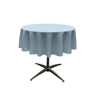 May include: A light blue round tablecloth draped over a table with a star-shaped base.