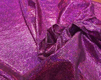 May include: Close-up of a shimmering purple fabric with a glittery texture. The fabric is folded and draped, showing its iridescent sheen.