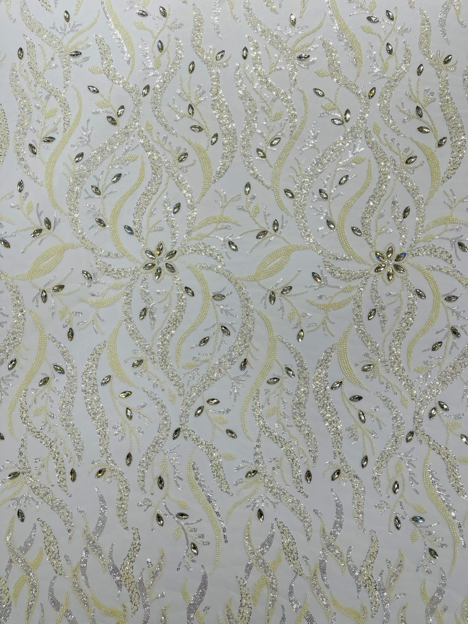 Ivory flowers embroider and heavy beaded on a mesh lace fabric-sold by the yard.