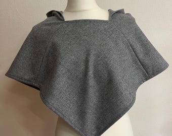 May include: A gray hooded poncho with a square neckline. The poncho is made of a soft, comfortable fabric.