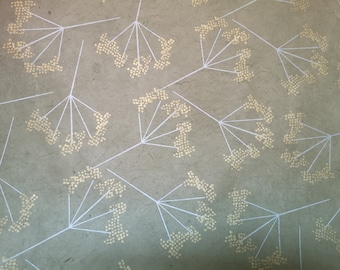 Puede incluir: Un fondo beige con un patrón repetitivo de líneas blancas que forman una forma de flor con puntos dorados. Los puntos están dispuestos en racimo para formar la forma de una flor.